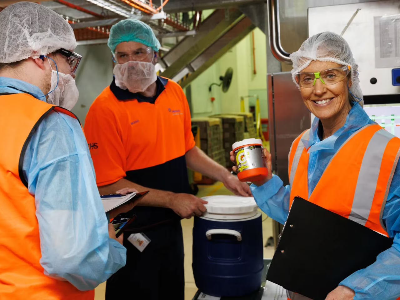 three people working in an industrial facility