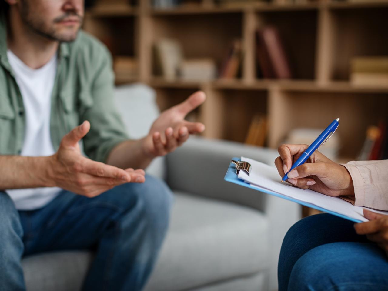 Two people conversing, one is writing on a clipboard