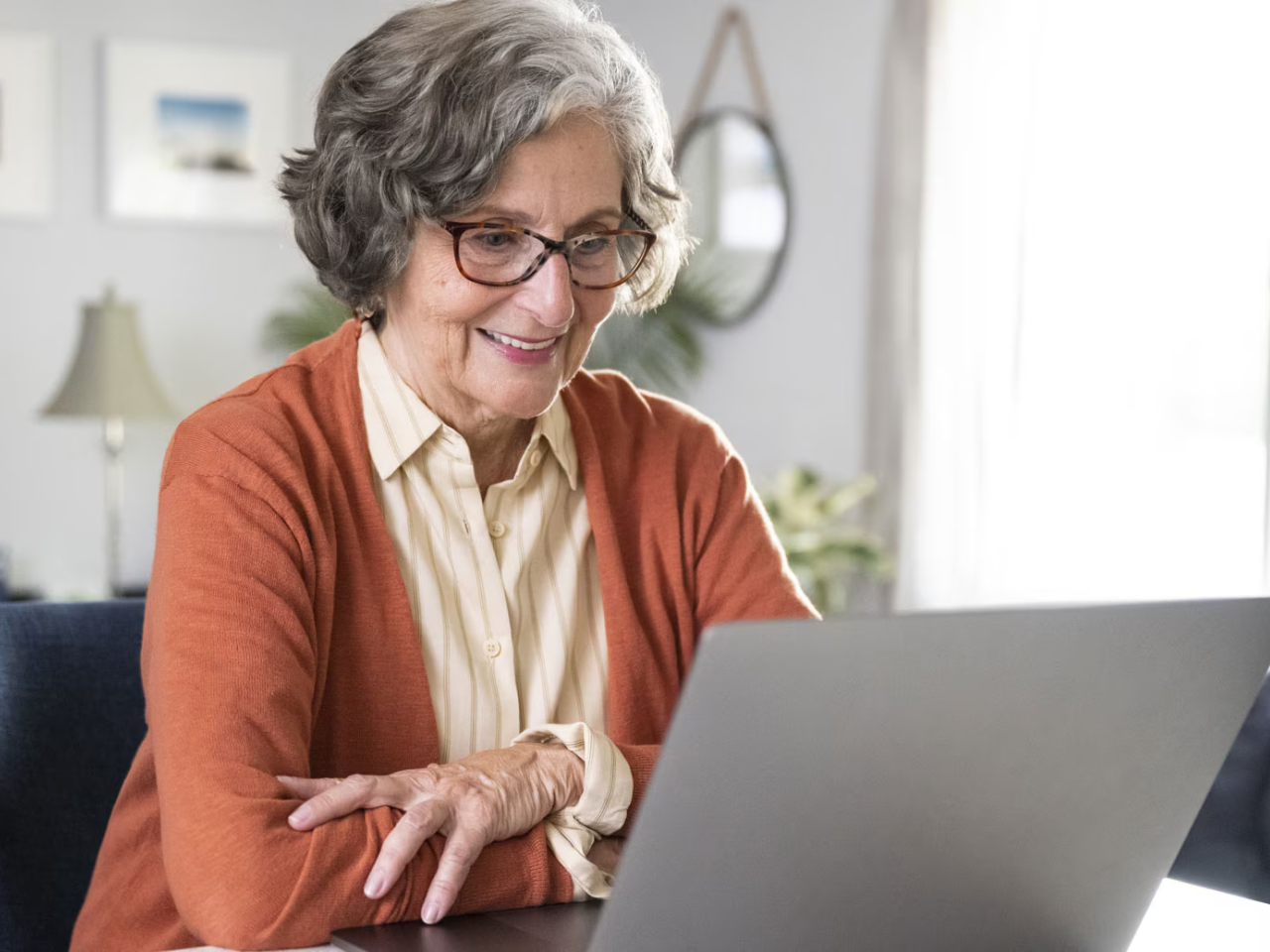 person smiling while looking at a laptop