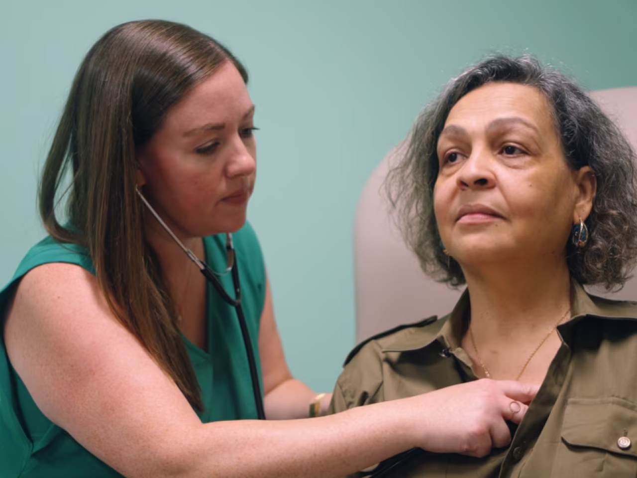 Healthcare worker listening to a patient's heart with a stethoscope