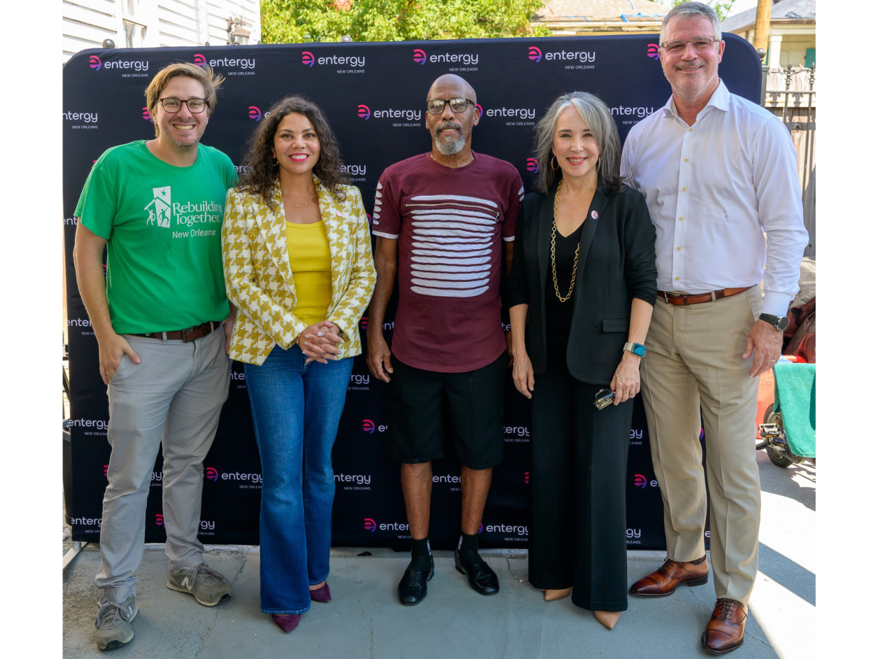 Five people standing together in front of an Entergy New Orleans backdrop