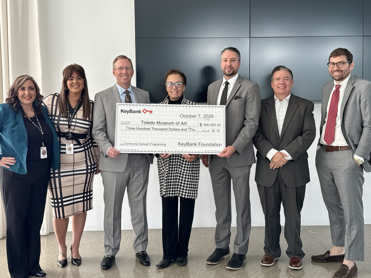 a small group posing with an oversized check