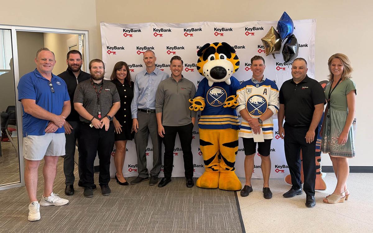 People standing together with Sabres mascot
