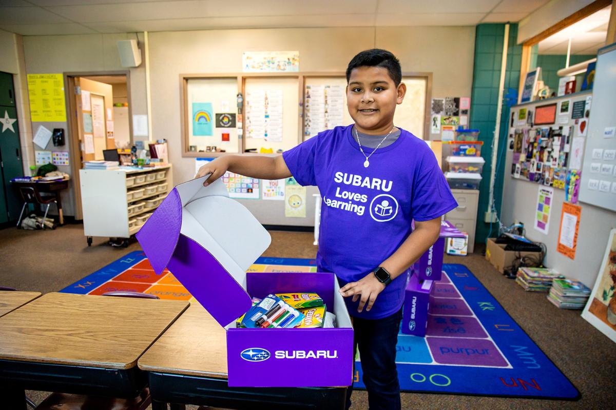 A child opening a purple box with supplies in it
