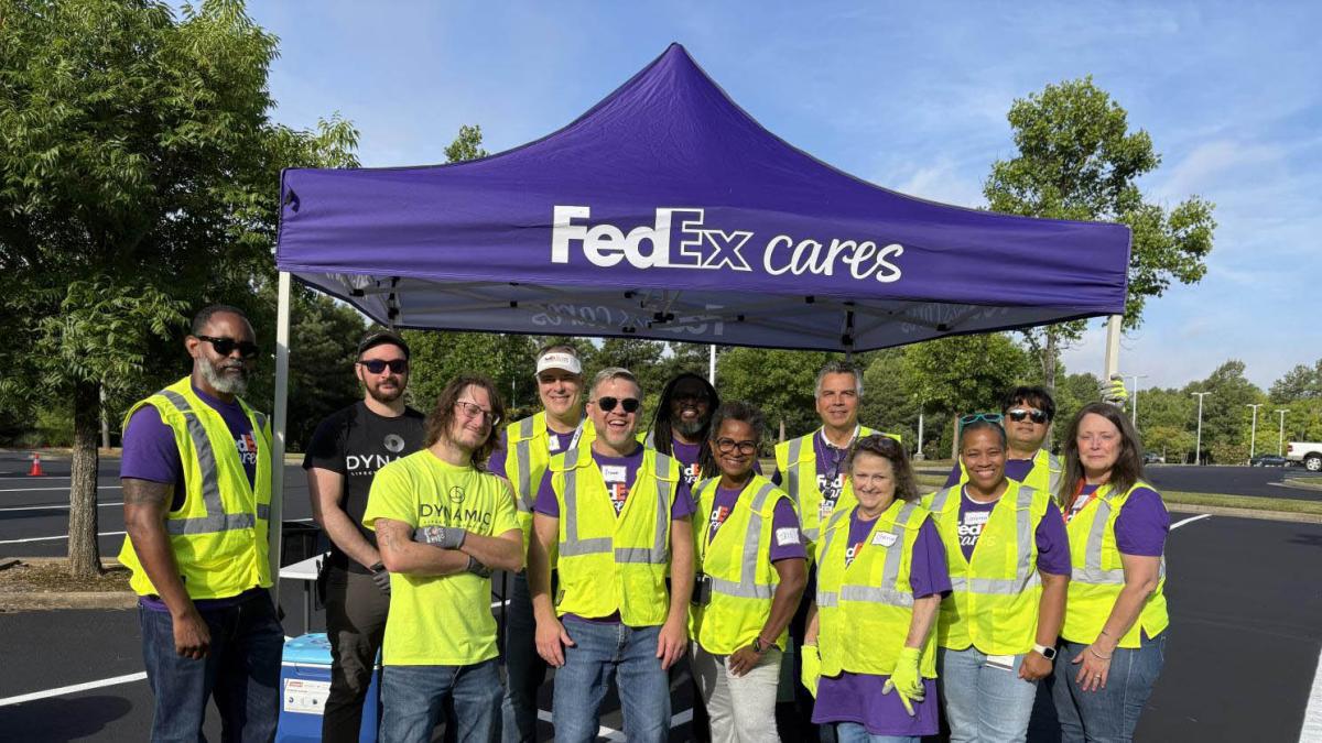 Volunteers outside next to a "FedEx Cares" tent