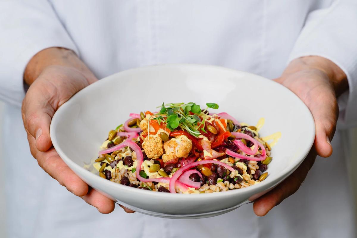 person holding out a dish of food