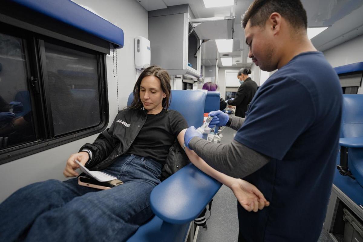 A woman donates blood during the LA Kings blood drive at Crypto.com Arena in Los Angeles, CA.