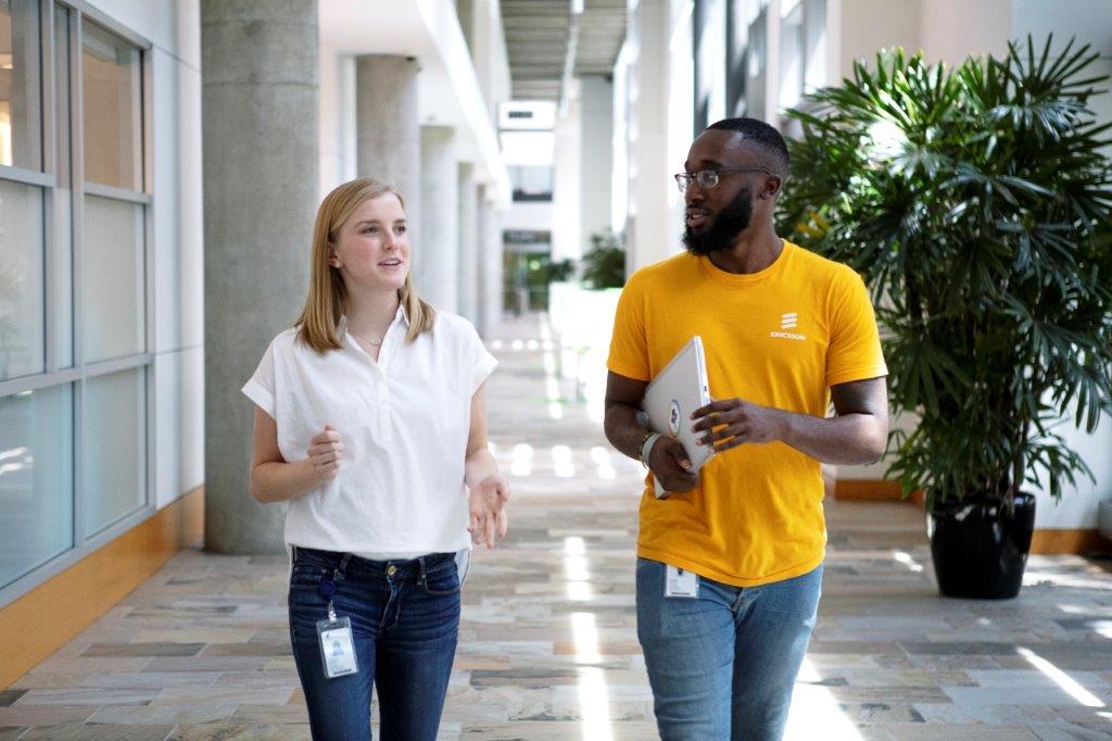 Two colleagues walking in a corridor and talking to each other