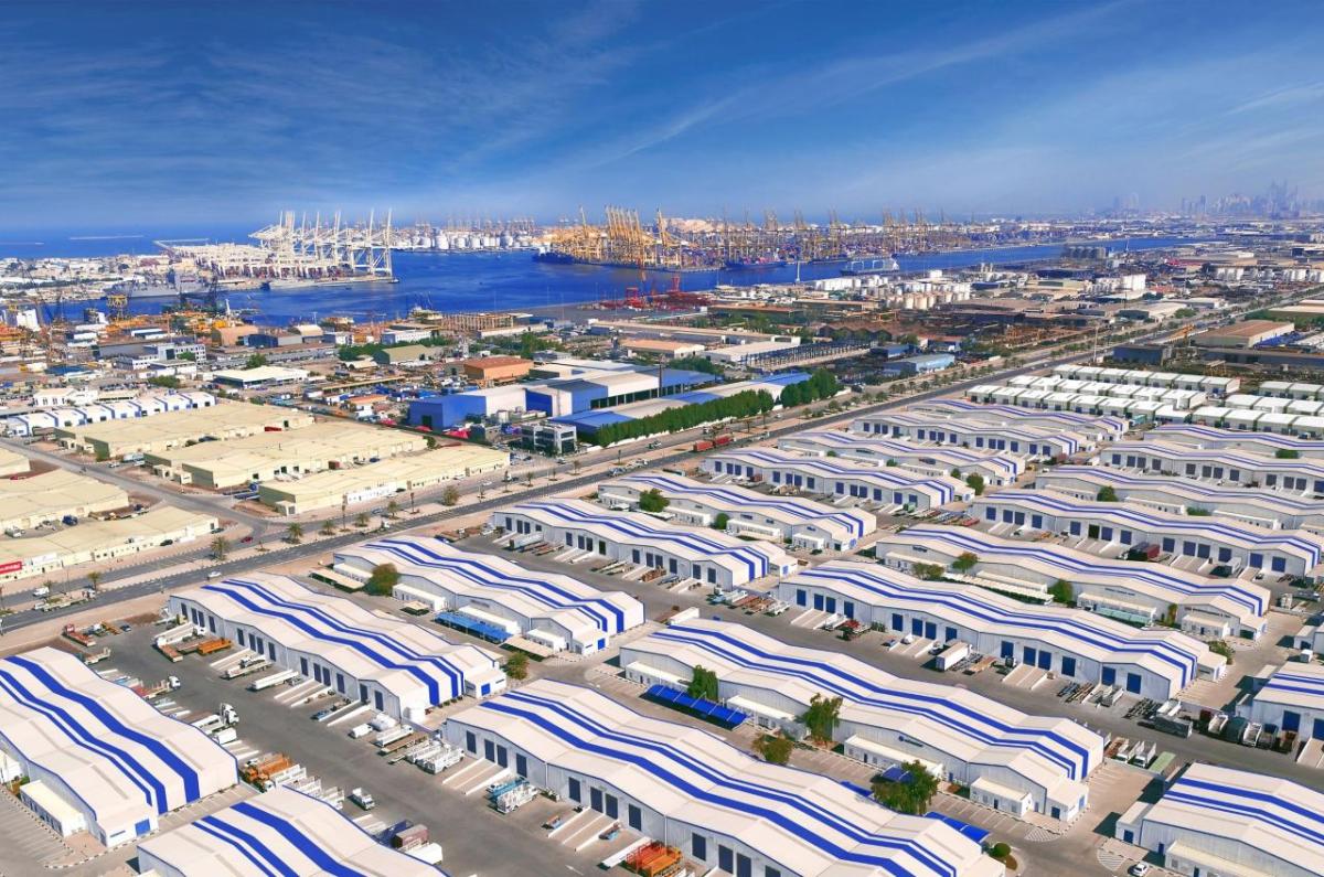 Aerial view of DP World’s Jebel Ali Free Zone in Dubai, showing expansive warehouses, logistics facilities, and the adjacent Jebel Ali Port with cranes and container ships along the waterfront.