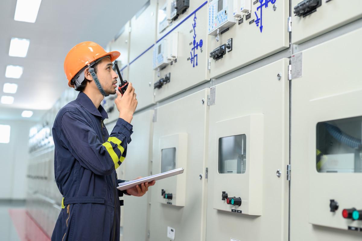 Facility worker in PPE speaking into a radio