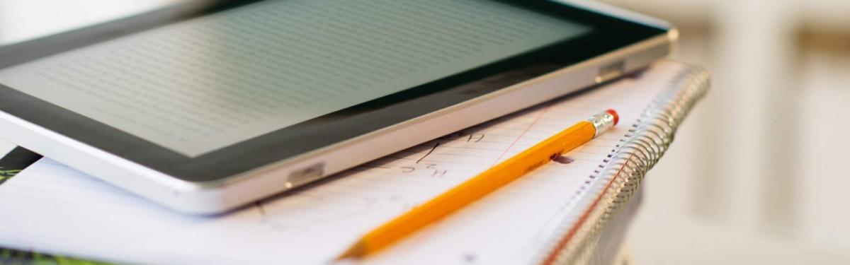 a tablet and a pencil and notebook