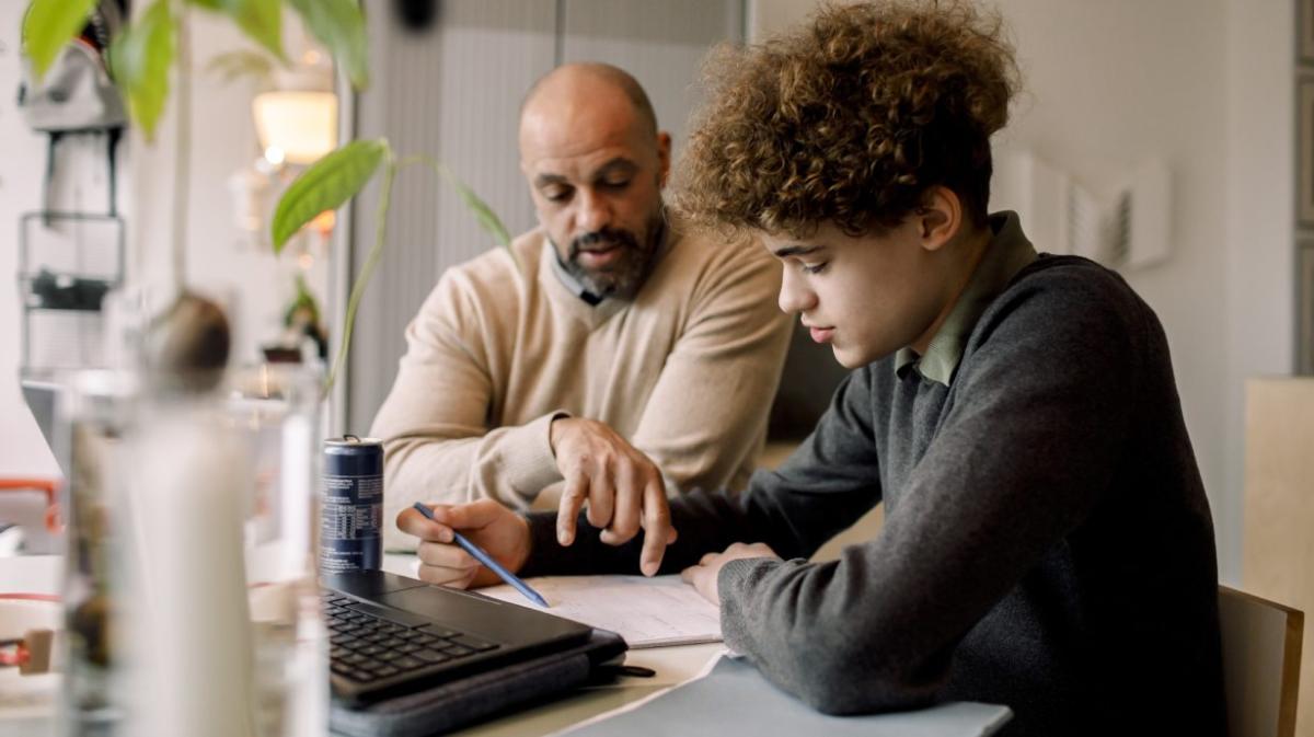 Parent and teenager looking at homework together
