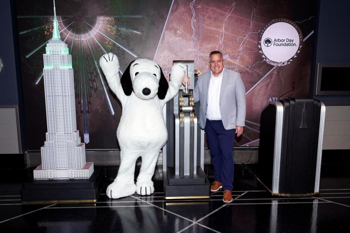 Arbor Day Foundation CEO Dan Lambe and Snoopy flip the switch the light the Empire State Building green.