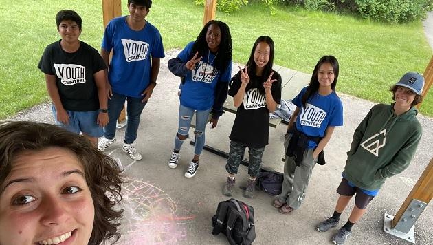 teens in Youth Central t-shirts and the photographer smiling in the foreground