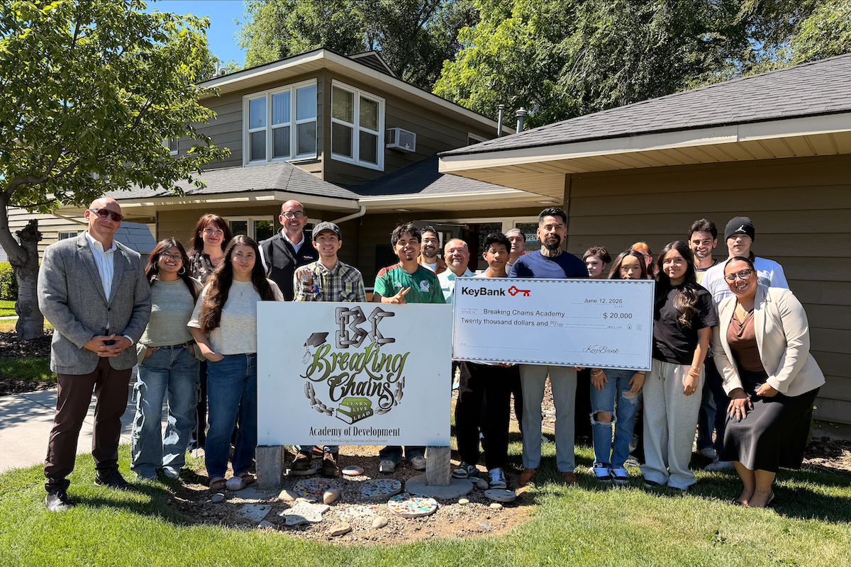 group of people holding celebratory check and banner