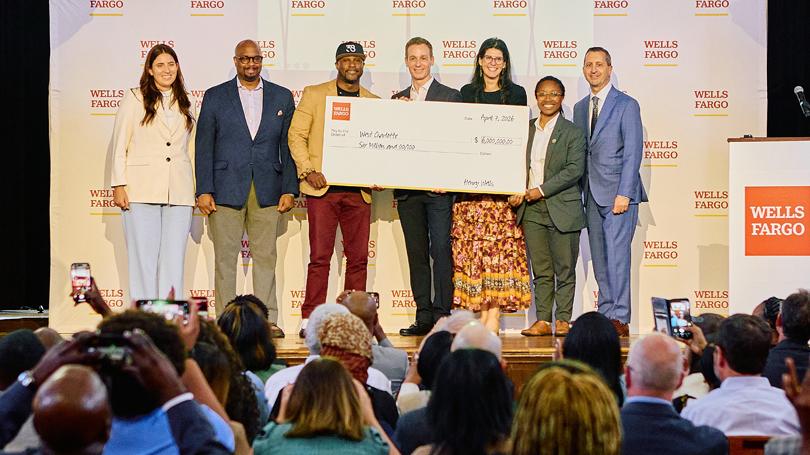 People on stage with big check