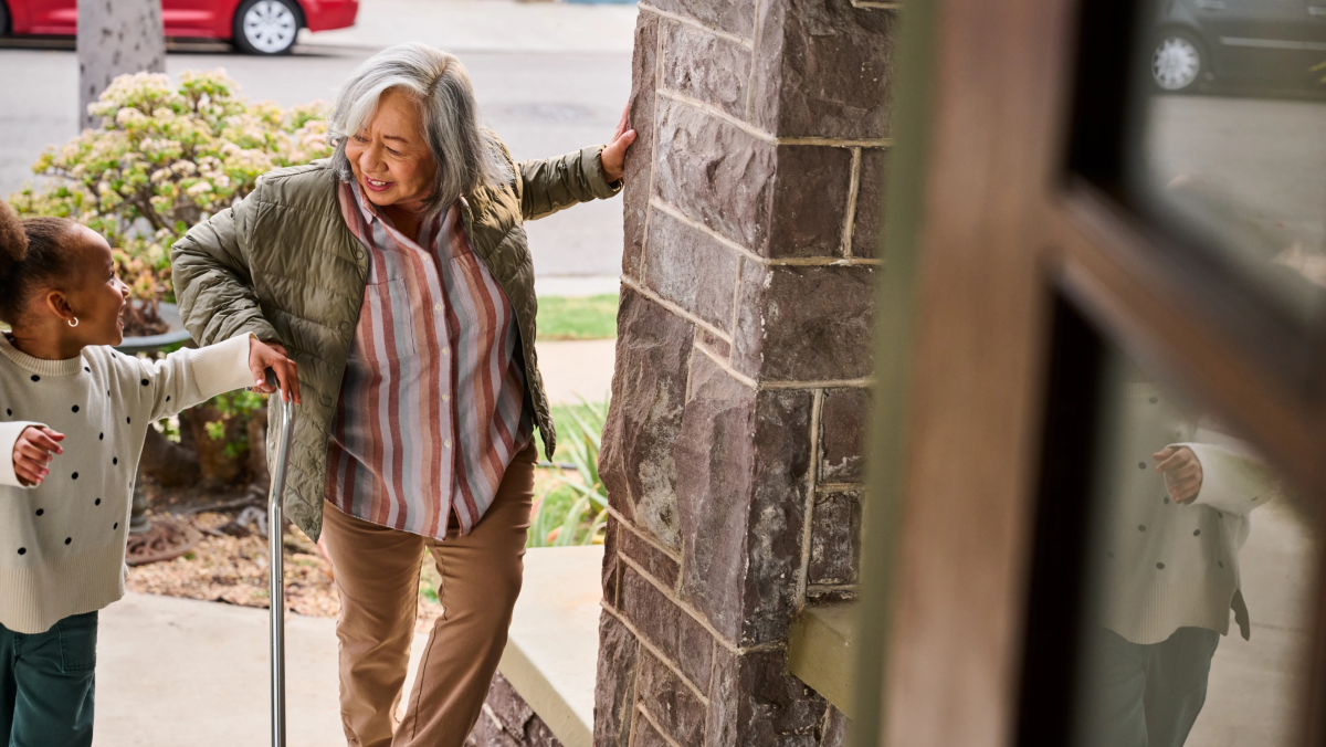 Child helping elderly person up the stairs