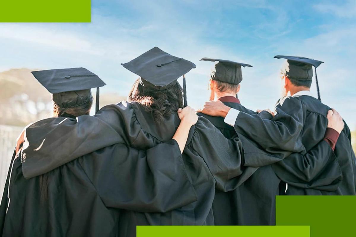 4 people in graduation robes with arms linked