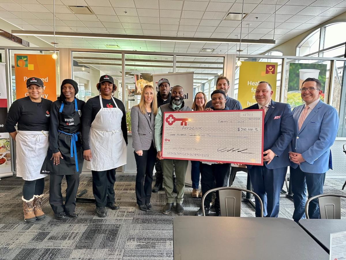 Representatives from KeyBank and Foodlink shown with a $300,000 grant check.