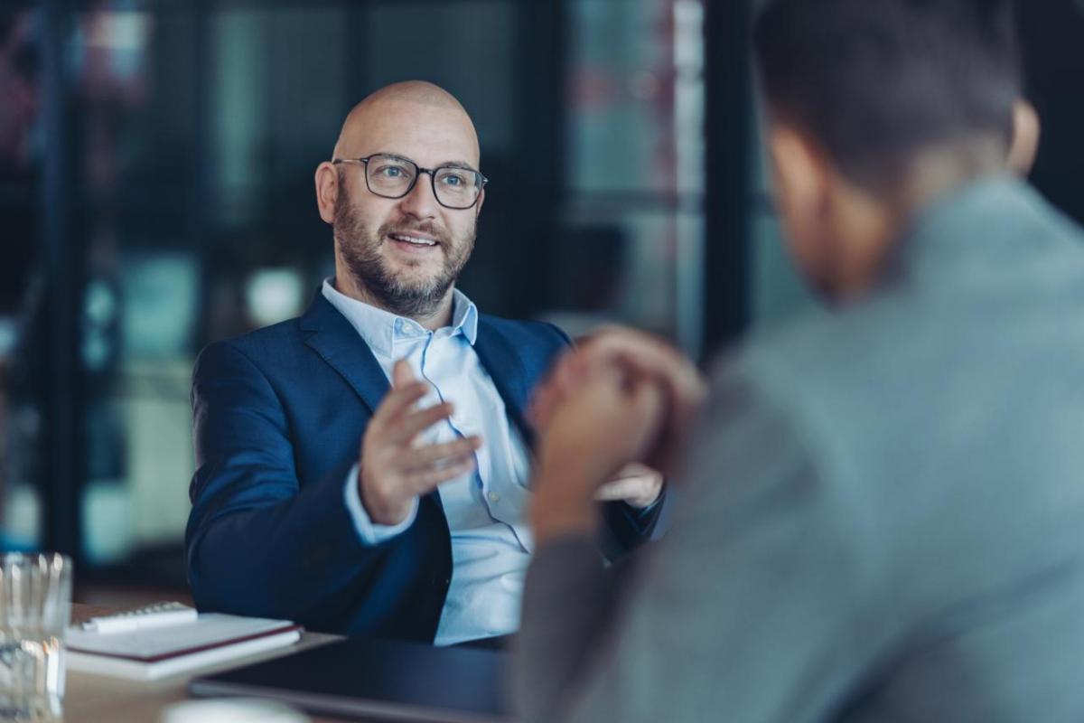 Two men in conversation at a desk