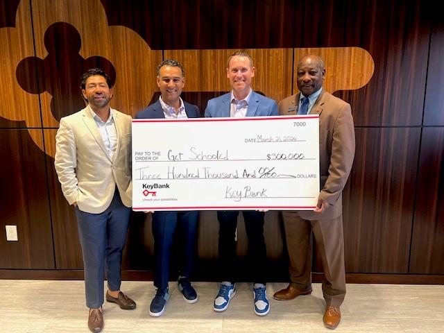 Get Schooled - people smiling with large check