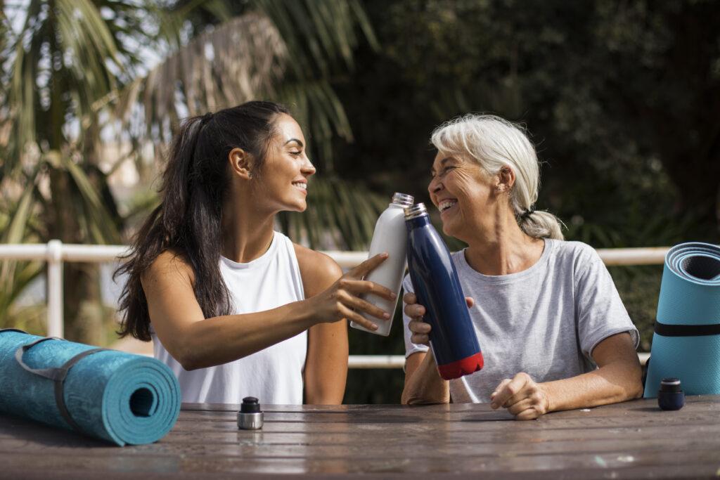 Two women drinking water after yoga.