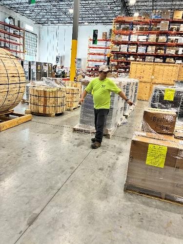 Worker in a Wesco warehouse preparing supplies for Hurricane Melissa relief.