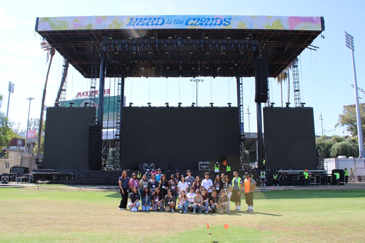 Students and event staff gather in front of the Head in the Clouds main stage during a behind-the-scenes venue tour.