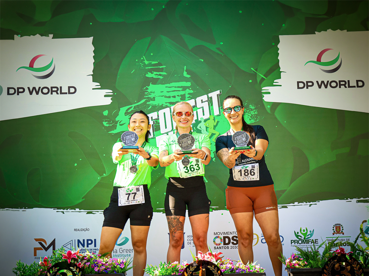 Three Forest Run participants hold awards at the DP World-sponsored event in Santos.