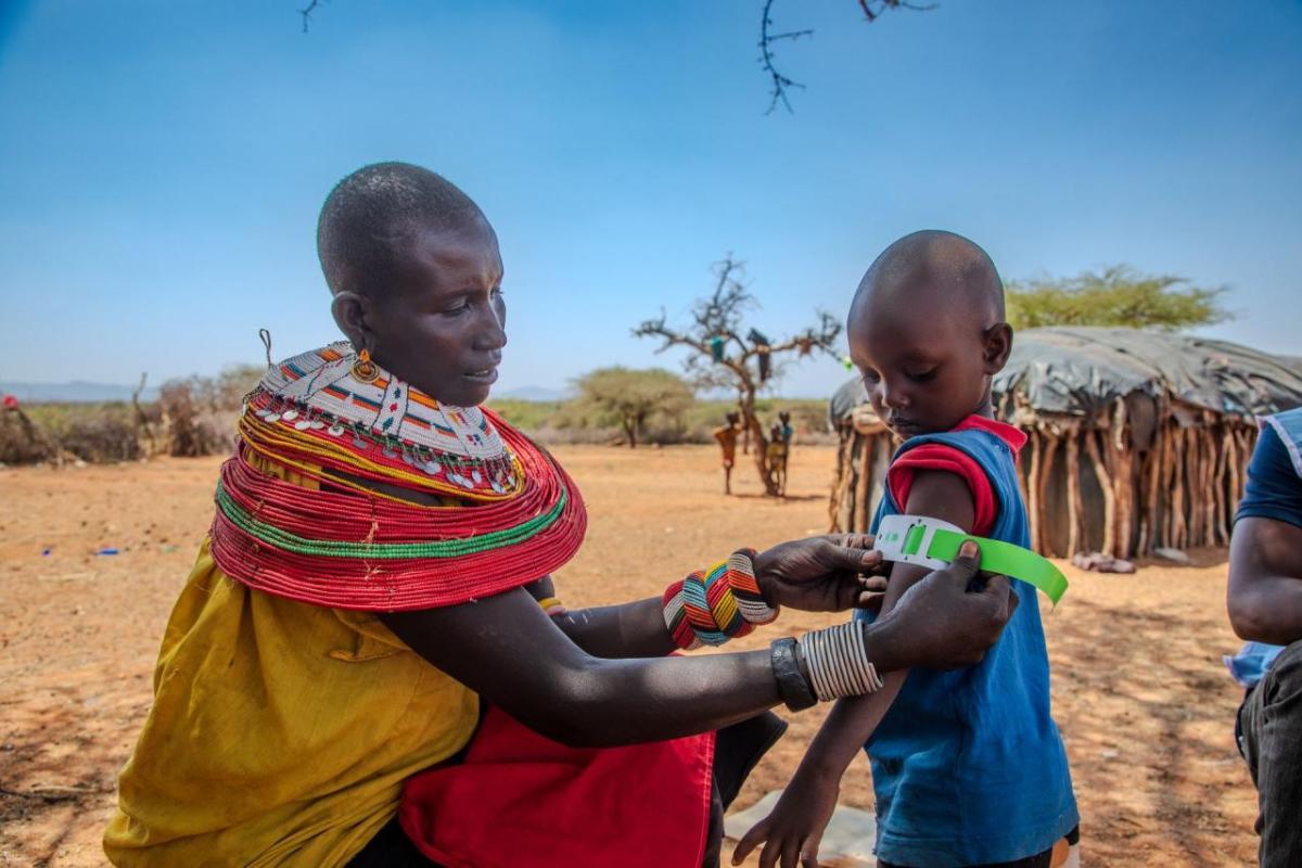 Rashei's mother checks his MUAC measurement after treatment. 