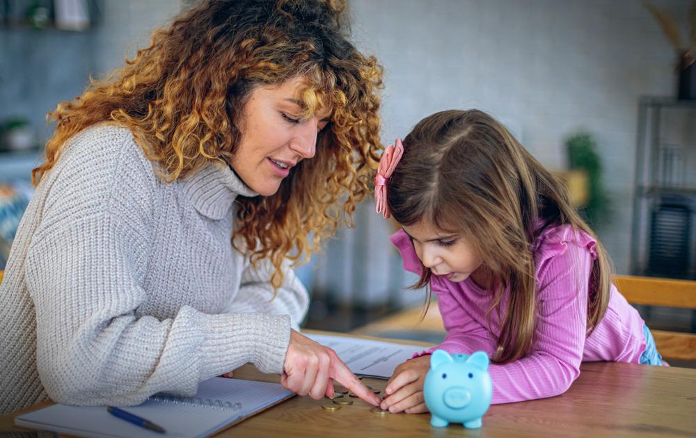 Woman and little girl discussing a lesson about money