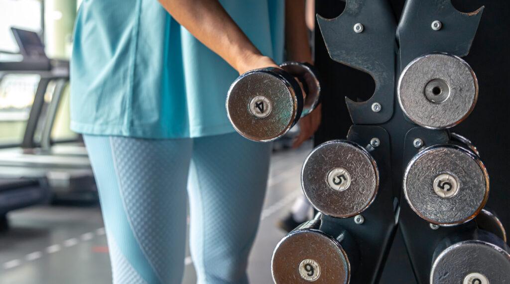 Woman picking up weights at the gym