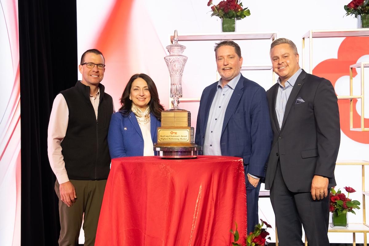 leaders standing around the trophy