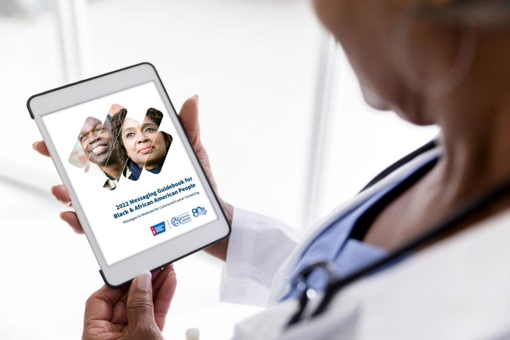 Doctor viewing the National Colorectal Cancer Roundtable's 2022 Messaging Guidebook on tablet
