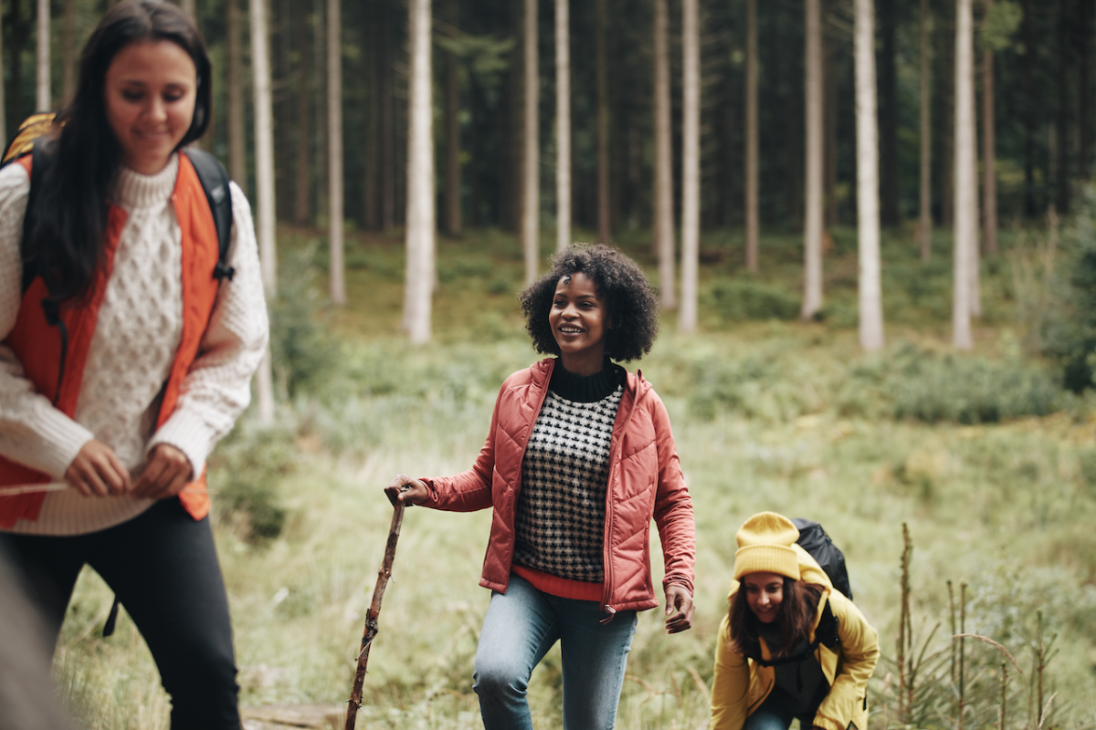 Woman and girls walking through forest