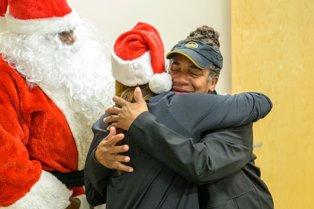 Cusomter hugging Entergy official wearing Santa