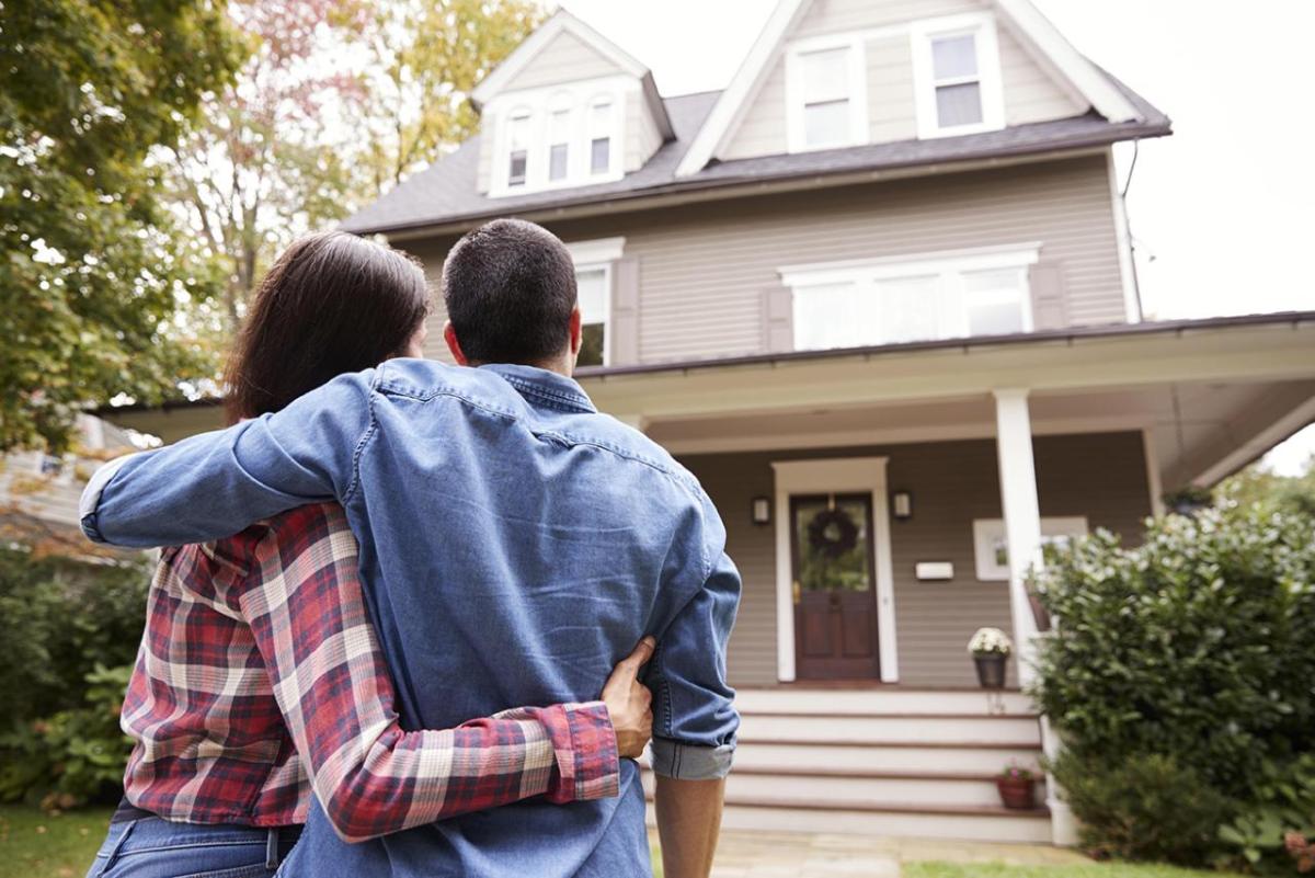 A couple embracing as they look at their new home.