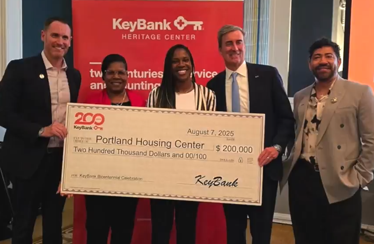 KeyBank team with the Arrive team with a $200,000 grant check.