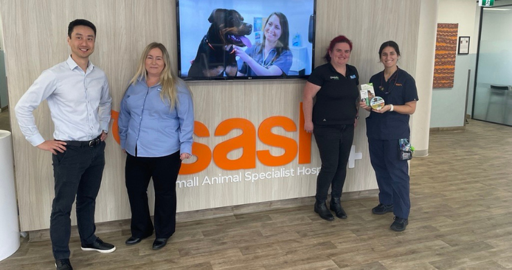 Four people standing by SASH sign 