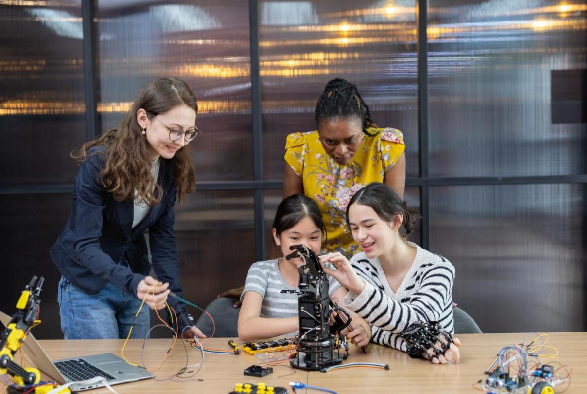 Tw girls building machines with instructors
