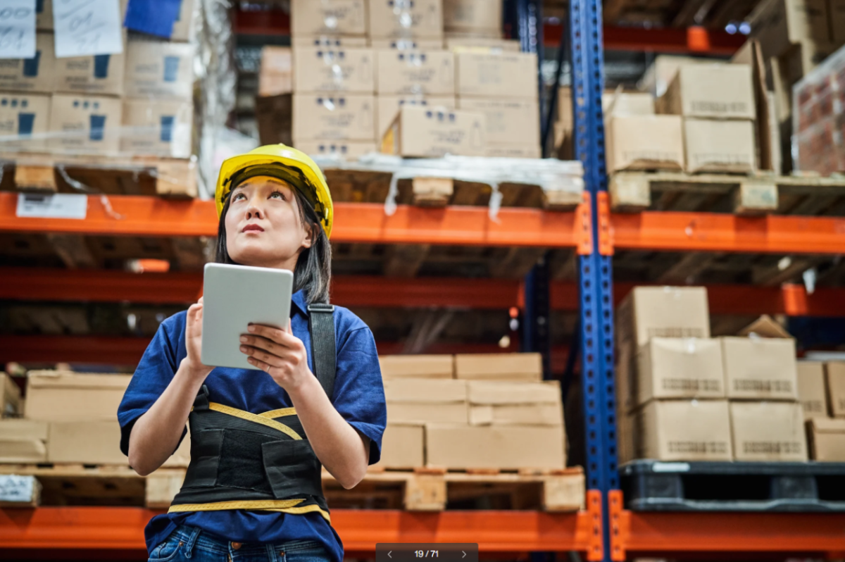 Worker Using Tablet in Warehouse Aisle