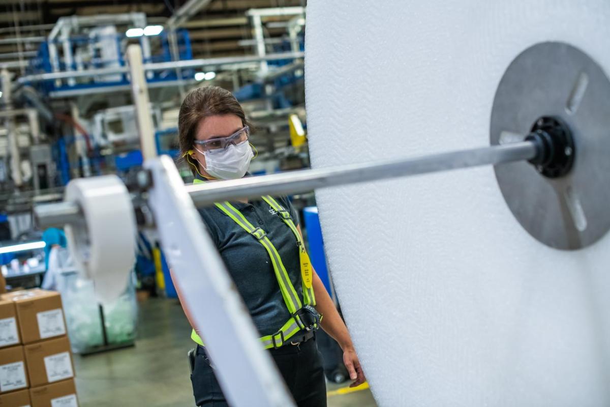 Manufacturing plant manager Karen Crisp on the shop floor looking at equipment 