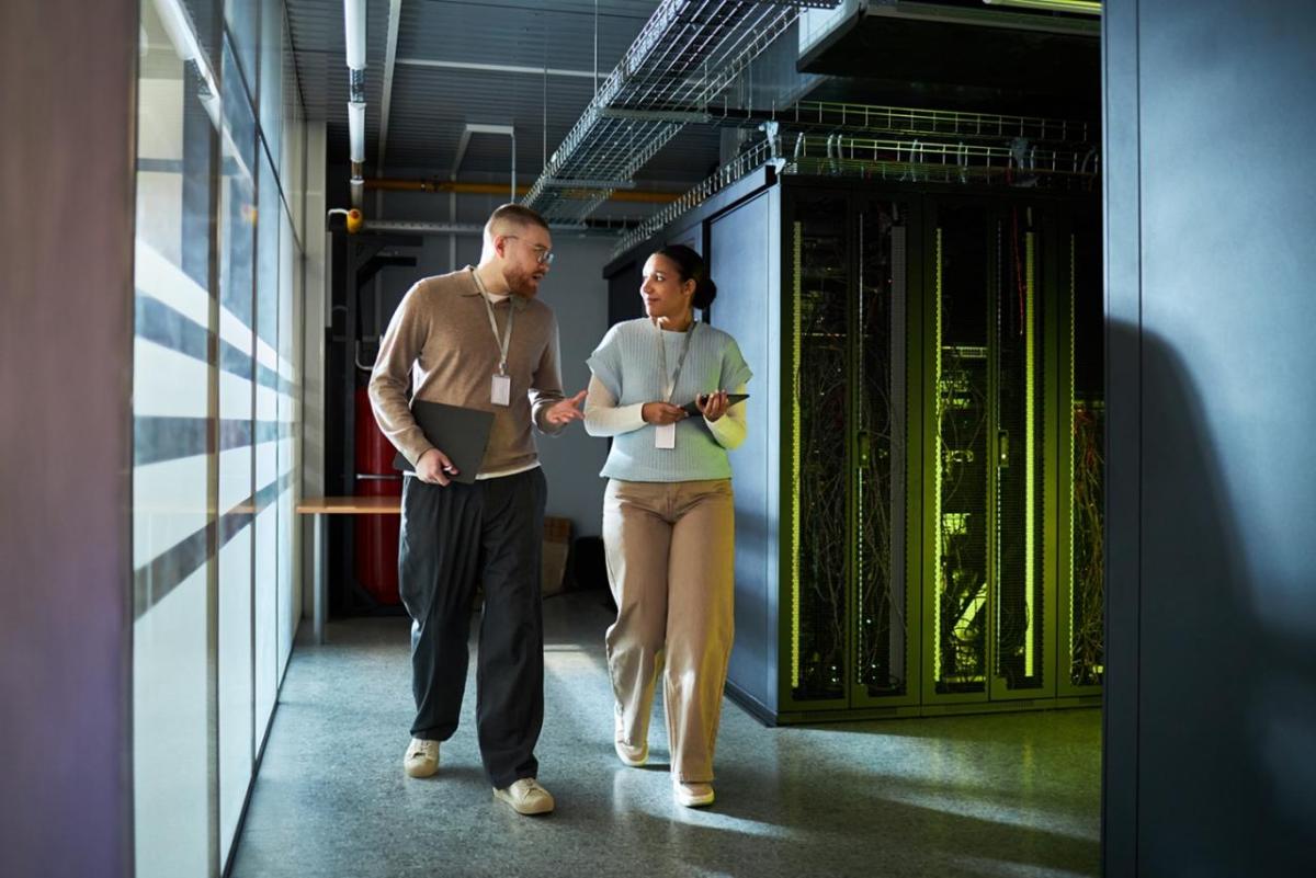 Two workers walking through a data center