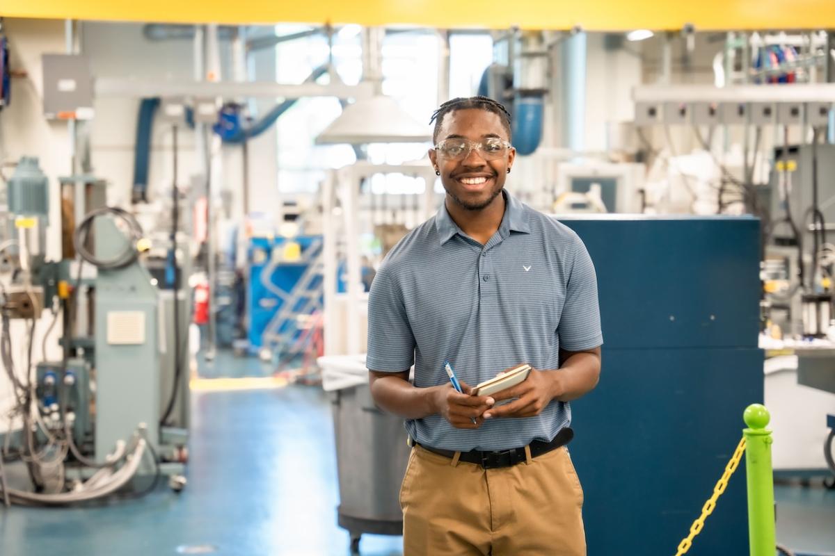 A person with a notepad in a factory.