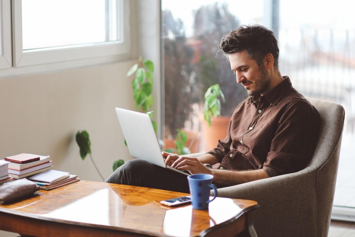 A person seated at a desk working on a laptop.