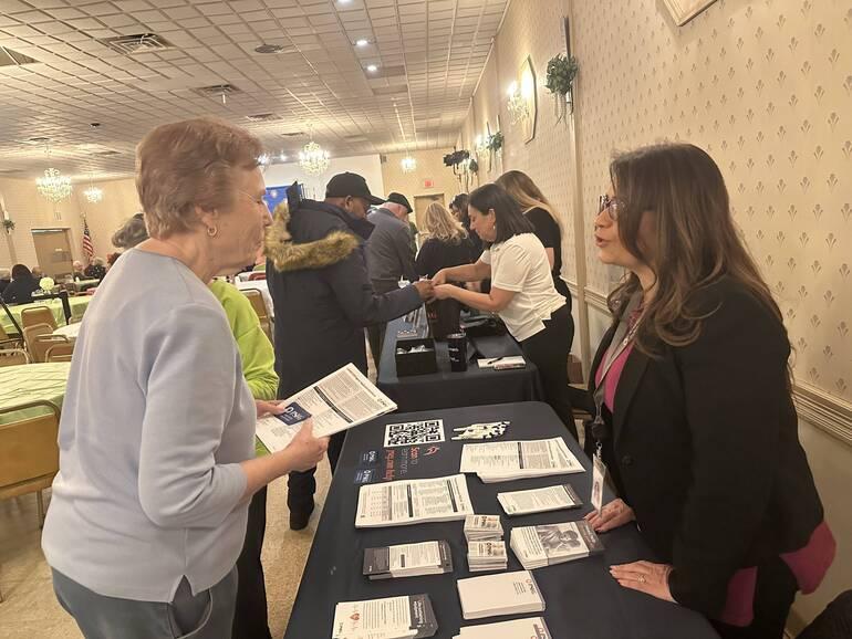 Senior speaking with someone at PSE&G's table at the event 