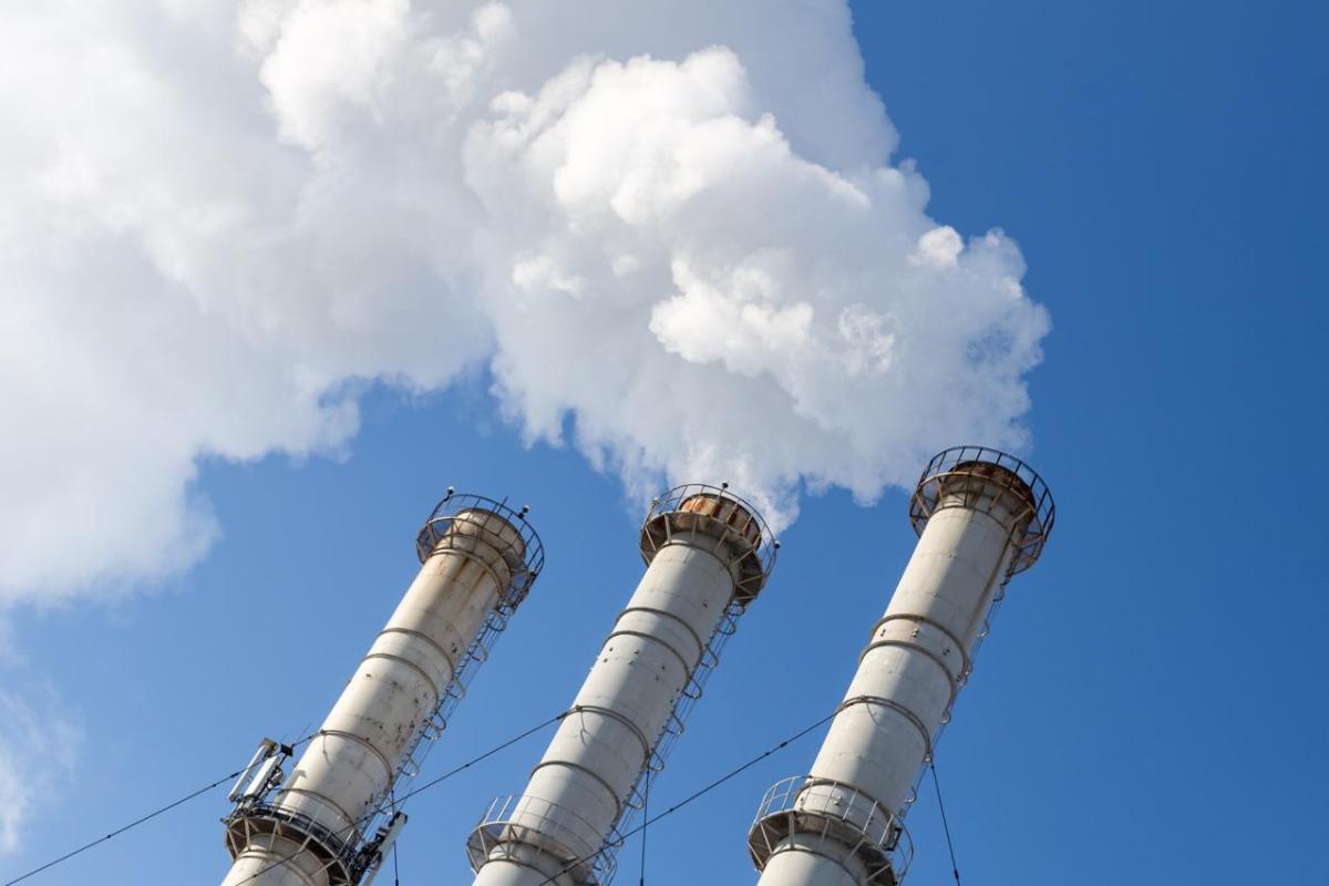 Smoking pipes making clouds against blue sky background