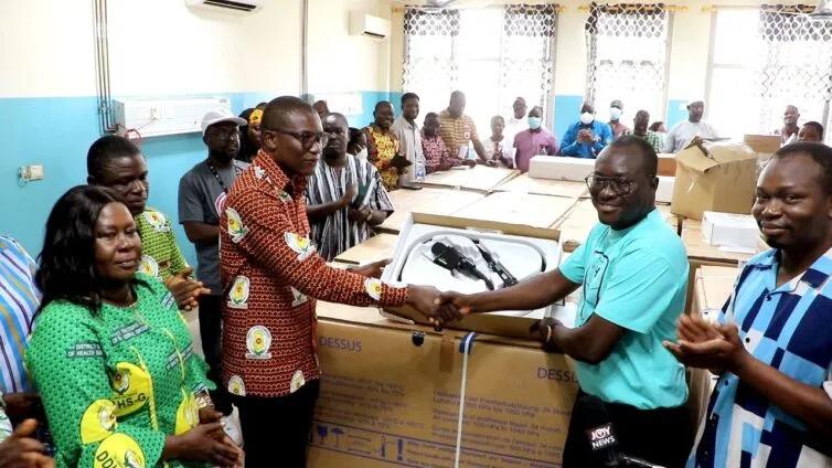 Ghana Medical Help representatives and healthcare workers gather around newly delivered hemodialysis equipment at a hospital in Ghana.