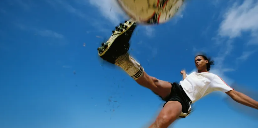 Female soccer player kicking a ball.