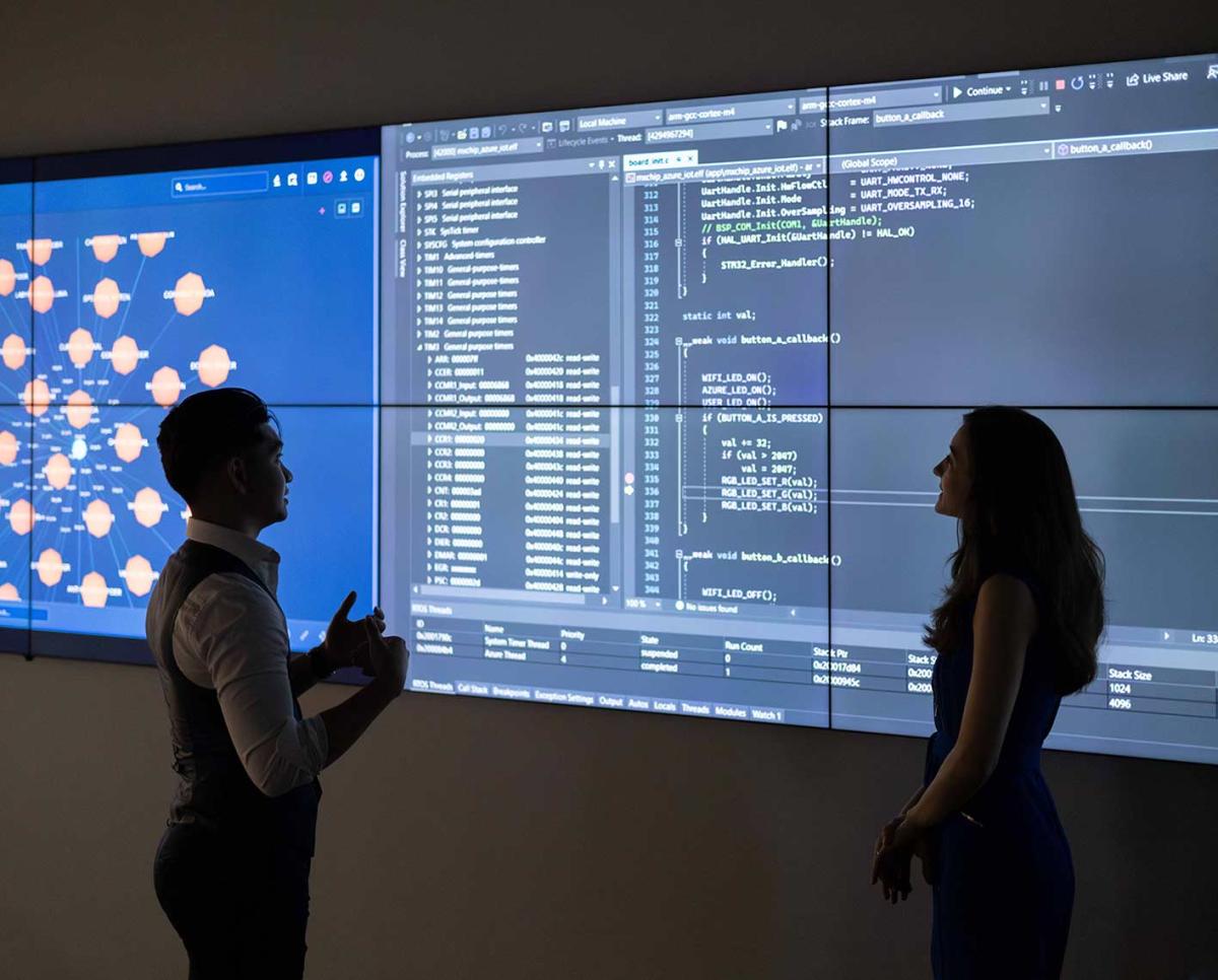 people looking at a computer screen of code